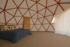 a bedroom of a yurt with a bed in it at GlampingWoodzen in Villa del Carbón