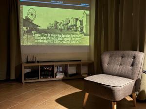 a chair sitting in front of a projection screen at BrezINNa - 200 let historie - moderní chalupa in Počátky