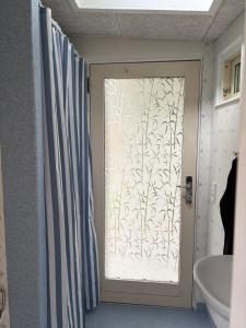 a bathroom with a door with a shower curtain at Skuret Maribo in Maribo