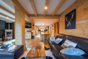 a living room with a leather couch and a table at Le Stam in La Salle-les-Alpes