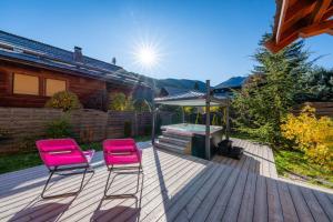 two pink chairs sitting on a deck with an umbrella at Le Stam in La Salle-les-Alpes