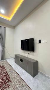 a living room with a flat screen tv on a wall at Baba Homestay in Macang