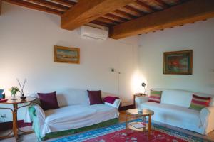 a living room with two white couches and a table at Dimora DiVino in Palazzone