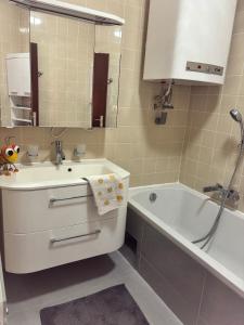 a bathroom with a sink and a tub and a mirror at Appartement Landzeit im Waldviertel in Steinbach +16 photos