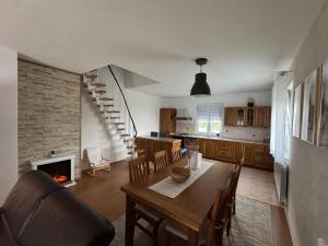 a kitchen and dining room with a table and a fireplace at Kuća za odmor NIMA in Gospić