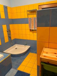 a yellow and blue bathroom with a tub and a sink at Ubytování Adina in Velké Pavlovice +52 photos