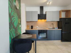 a kitchen with a table and a black refrigerator at Parkcity Katowice Bogucice in Katowice +102 photos
