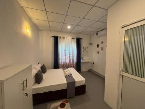 a small room with a bed and a window at The Cottage Weligama in Weligama +6 photos