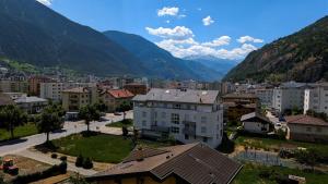 a view of a city with mountains in the background at Apartment Above the Rooftops - Mountain Panorama in Naters