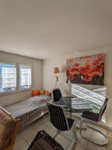 a living room with a bed and a glass table at Apartment Above the Rooftops - Mountain Panorama in Naters
