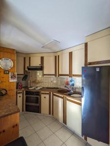 a kitchen with wooden cabinets and a stainless steel refrigerator at Apartment Above the Rooftops - Mountain Panorama in Naters +16 photos