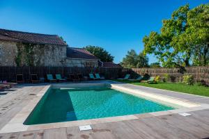 a swimming pool with chairs and a fence at Hôtel Le Groom in Laprade