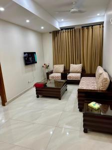 a living room with two couches and a tv at Premium Pavilion in Islamabad