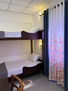 a room with two bunk beds and a window at The Cottage Weligama in Weligama