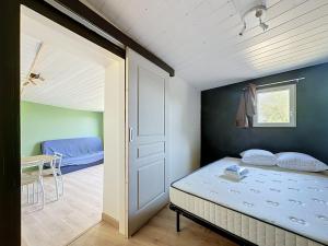 a bedroom with a bed and a door and a table at Maisonnette avec jardin privé in Secondigny
