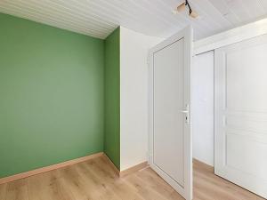 an empty room with green and white walls and a door at Maisonnette avec jardin privé in Secondigny