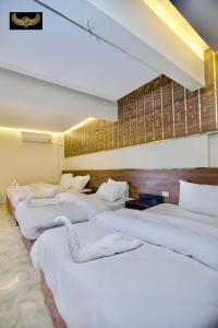a row of white beds in a room at Comfort Pyramids Inn in Cairo +108 photos