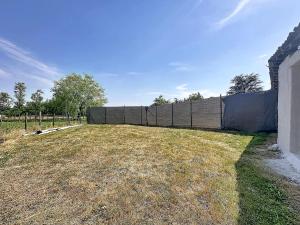 an empty yard with a fence in the background at Maisonnette avec jardin privé in Secondigny