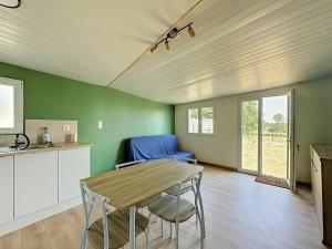 a kitchen and dining room with a table and chairs at Maisonnette avec jardin privé in Secondigny