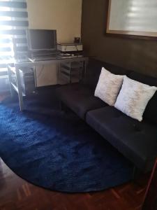 a blue couch with two pillows on a blue rug at Apartamento SC in Estación Pamplona
