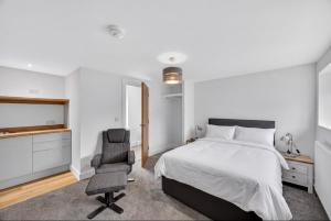 a bedroom with a bed and a desk and a chair at Stoney suites in Stonehaven