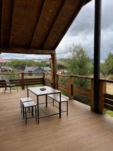 a patio with a table and two benches on a deck at Cabaña Palafito in Coelemu