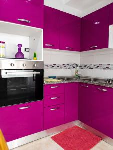 a kitchen with purple cabinets and a red rug at ben mesaaoud in Kelibia
