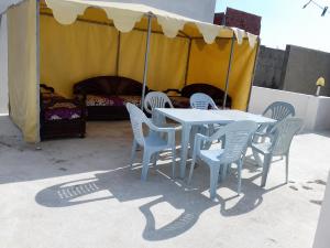 a table and chairs and a tent with a bed at ben mesaaoud in Kelibia