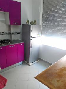 a kitchen with purple cabinets and a refrigerator at ben mesaaoud in Kelibia