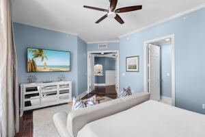 a bedroom with blue walls and a ceiling fan at The Alexander in Rosemary Beach +29 photos