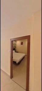 a mirror in a room with a bed in it at HOTEL MEREDIAN GRAND INn in Shamshabad