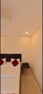 a bedroom with a bed with red pillows on it at HOTEL MEREDIAN GRAND INn in Shamshabad