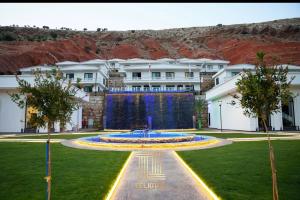 a building with a fountain in the middle of a park at Telimas tourism in Erbil