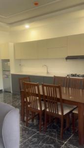a kitchen with a wooden table and wooden chairs at Telimas tourism in Erbil