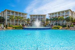 a swimming pool with a fountain in front of two buildings at The Alexander in Rosemary Beach