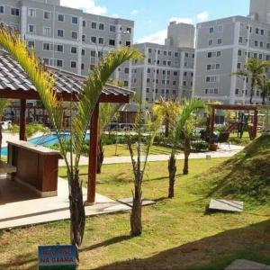 a group of palm trees in a park with buildings at Cantinho aconchegante in Londrina
