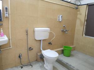 a bathroom with a toilet and a shower with a green bucket at Hotel Dream Rooms- Friendly Rooms in Salt Lake City