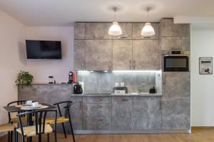 a kitchen with stainless steel cabinets and a table and chairs at Apartamenty 9A Zgorzelec - Centrum in Zgorzelec +4 photos