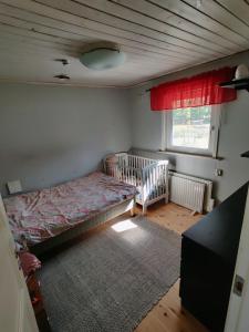 a bedroom with a crib and a bed in it at Ulriksdal in Ulriksdal