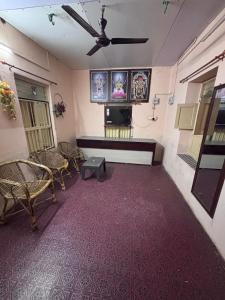 a living room with a ceiling fan and a tv at CHIDAMBARAM Bala Residency in Chidambaram