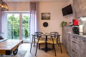 a kitchen and dining room with a table and chairs at Apartamenty 9A Zgorzelec - Centrum in Zgorzelec