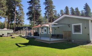 a small green house with a porch in a yard at Ulriksdal in Ulriksdal