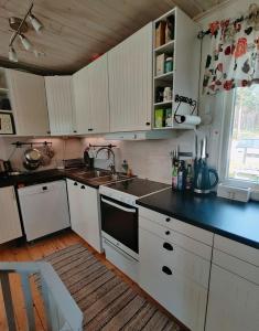 a kitchen with white cabinets and a black counter top at Ulriksdal in Ulriksdal