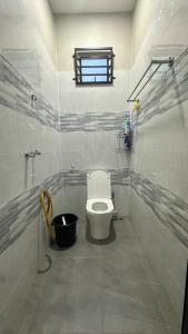 a bathroom with a toilet and a window at Baba Homestay in Macang +15 photos