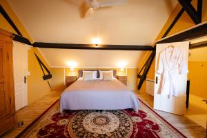 a bedroom with a bed and a dress hanging on the wall at Chambres d’hôtes La Joyeuse in Préveranges