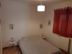 a bedroom with a bed and a red curtain at RDJ Proche mer "L'Oustaou Cabriole" in Saint-Cyr-sur-Mer
