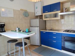 a small kitchen with blue cabinets and a white table at casa marina in Pettenasco