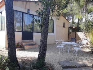 a patio with a table and chairs in front of a house at RDJ Proche mer "L'Oustaou Cabriole" in Saint-Cyr-sur-Mer