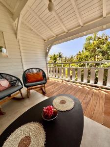 a porch with a table and chairs on a deck at Orient Bay charming in Saint Martin