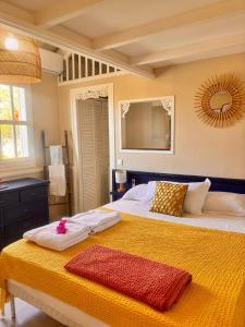 a bedroom with a large bed with a yellow blanket at Orient Bay charming in Saint Martin